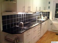 a kitchen with black and white tiles on the counter tops, cabinets and cupboards