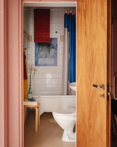 an open door leading to a bathroom with a toilet and bathtub