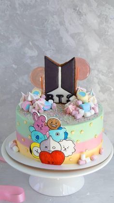 a colorful cake with an open book on it's top and decorations around the edges