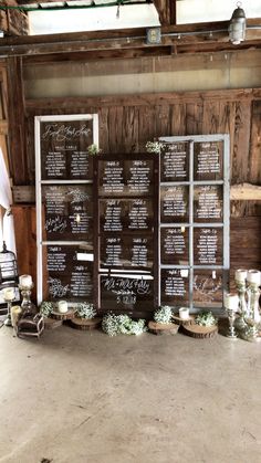 the wedding seating chart is set up in front of an old wooden wall with candles and flowers