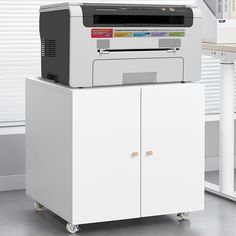 a printer sitting on top of a white cabinet