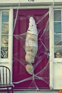 a door covered in plastic wrap and spider web