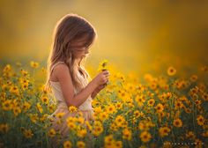 a girl in a field of sunflowers looking at her cell phone with the caption's name on it