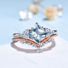 a ring with an aqua blue topazte surrounded by white and rose gold accents