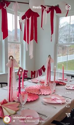 the table is set with pink and white decorations