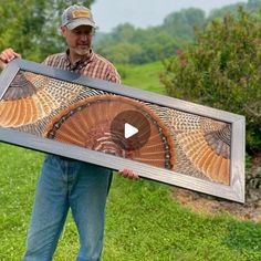 a man holding up a large framed turkey art piece