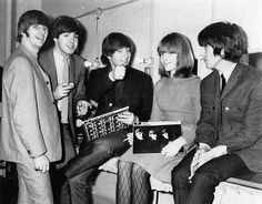 the beatles are posing for a photo in their dressing room with one holding an album