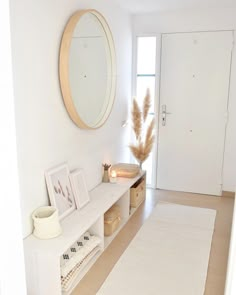 a white room with some drawers and a mirror