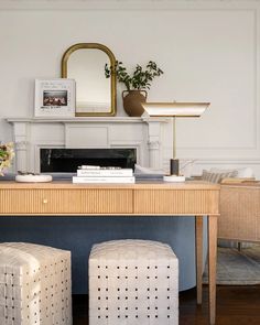 a table with two stools and a mirror above it