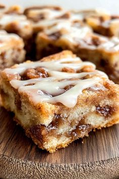 cinnamon roll with icing sitting on top of a wooden cutting board