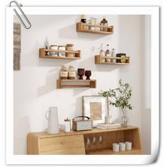 three wooden shelves on the wall above a dresser with cups and vases, one shelf holding various items