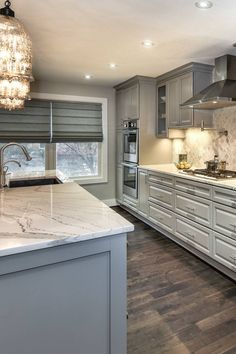 a large kitchen with marble counter tops and stainless steel appliances