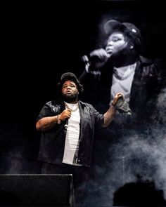 a man standing on top of a stage holding a microphone