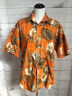 "Vintage Mens Orange Floral Hawaiian Shirt Mens Hawaiian Tropical Shirt by Pierre Cardin Color is orange with brown and beige Hibiscus and palm fronds Short sleeve Buttons up front One chest pocket on L Straight hem  Materail is 100% cotton Cotton is great Fabric for the summer  Mens size Large Measurements Chest 49\" Length 30\" Mens shirt but can easily be considered Unisex Very good vintage condition with no noted flaws Garment has been laundered and is ready to wear. Even though this is cott