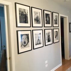 a wall with many pictures hanging on it's side in a living room next to a doorway