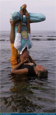 three people are in the water with their hands on each other's shoulders and one person is upside down