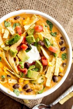 a white bowl filled with taco soup and tortilla chips