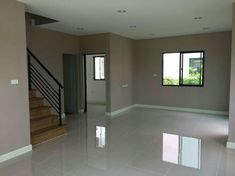 an empty room with tile flooring and stairs leading up to the second story window