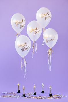 white balloons with gold writing on them