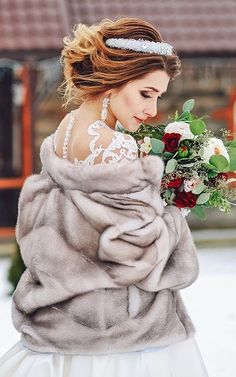 a woman in a fur coat holding a bouquet