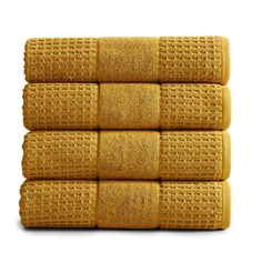 four yellow towels stacked on top of each other in front of a white background,