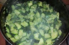 a pan filled with sliced cucumbers cooking on top of a stove burner