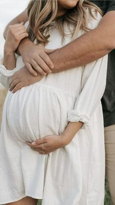 a pregnant woman is holding her husband's belly