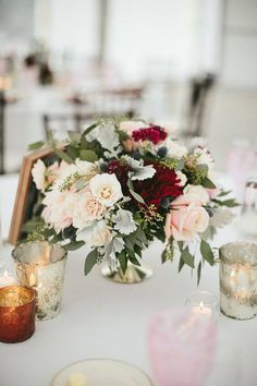 a table topped with lots of flowers and candles