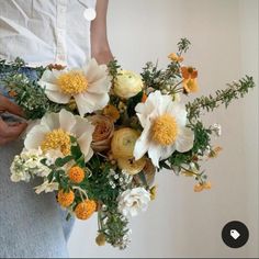 a person holding a bouquet of flowers in their hands