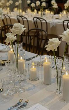 the table is set with white flowers and candles for an elegant dinner or reception party