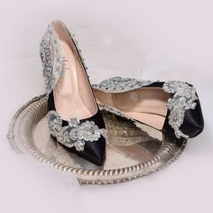 a pair of black and silver high heeled shoes on top of a metal tray