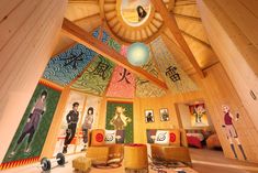 a room with wooden walls and colorful paintings on the ceiling, along with other decorations