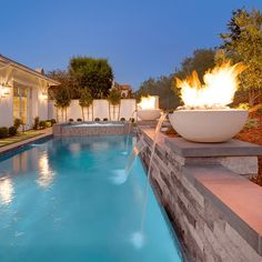 a fire pit sitting next to a swimming pool in a home's back yard