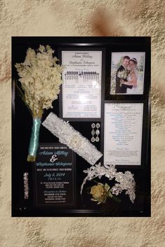 a wedding display with flowers and pictures on the wall next to it's frame