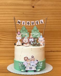 a cake decorated with animals and the word mimubi on top is sitting on a table