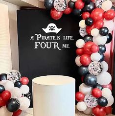 a table with balloons and a sign that says pirate's life four me