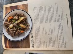 a plate of food sitting on top of a wooden table next to an open book