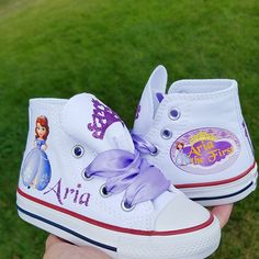 "I can do these in pink Converse if desired, just put that in the notes to seller box during check out. These Converse adorable! Each tongue has a lavender glitter crown, the right shoe has Sofia and your little one's name in glittery purple. The left shoe will come as shown but with your daughter's name and then \"the First\". Lavender double faced satin ribbon ties. If you want silver or gold crystals on the toes, please select that option during check out." Purple Canvas Shoes With Rubber Sole And Round Toe, Purple Canvas Shoes With Round Toe And Rubber Sole, Gold Crystals, Glitter Crown, Pink Converse, Custom Converse, Sofia The First, Shoes Custom, Girls Sneakers