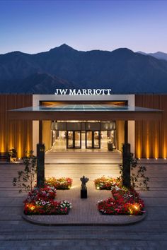 the front entrance to jw marriot hotel at dusk with mountains in the background