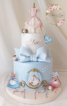 there is a blue and white cake with princess decorations on the top, along with other items