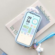 a cell phone keychain with a cartoon character on the front and an alarm clock on the back