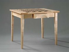 a wooden table with a chess board on it's top and drawer at the bottom