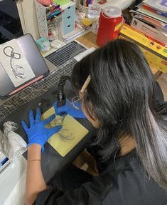 a woman in blue gloves working on a piece of paper