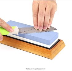 a person using a sharp knife to cut up a piece of paper on top of a book