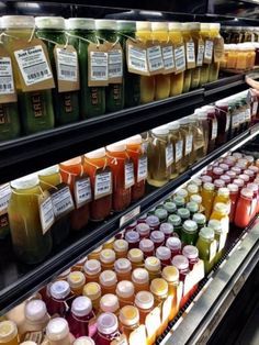 there are many different types of juices on the shelves in this store, each with their own label