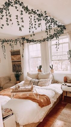 a bed sitting under a window next to a wooden floor covered in leaves and vines