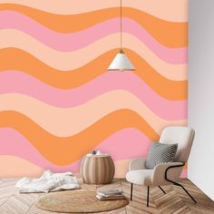 an orange and pink wave wallpaper in a living room with a chair, rug and lamp