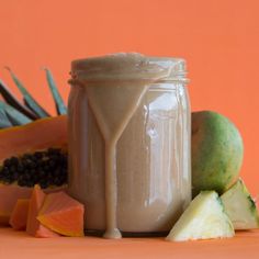 a jar filled with liquid next to sliced fruit