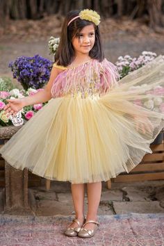 Yellow tulle flared dress with feathers and beaded hand embroidered bodice and sleeve.
Components: 1
Pattern: Hand embroidered
Type Of Work: Feathers, Beads
Neckline: Asymmetric Neck
Sleeve Type: Asymmetric Sleeves
Fabric: Tulle, Lining : Satin
Color: Yellow
Other Details: 
Back bow detailing
Attached lining
Note : Head accessory worn by the child model is not for sale.
Occasion: Party - Aza Fashions Party Dresses With Feathers And Tulle Material, Tulle Party Dress With Feathers, Party Dresses With Feathers And Tulle, Feather Trim Tulle Dresses For Pageants, Fitted Tulle Dress With Feathers, Tulle Dresses With Feather Trim For Dress-up, Embellished Tulle Dress For Dress-up Occasions, Princess Dresses With Feather Trim For Dress-up, Princess Style Dresses With Feather Trim For Dress-up