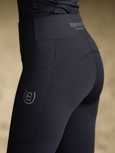 the back view of a woman's leggings in black with white logo